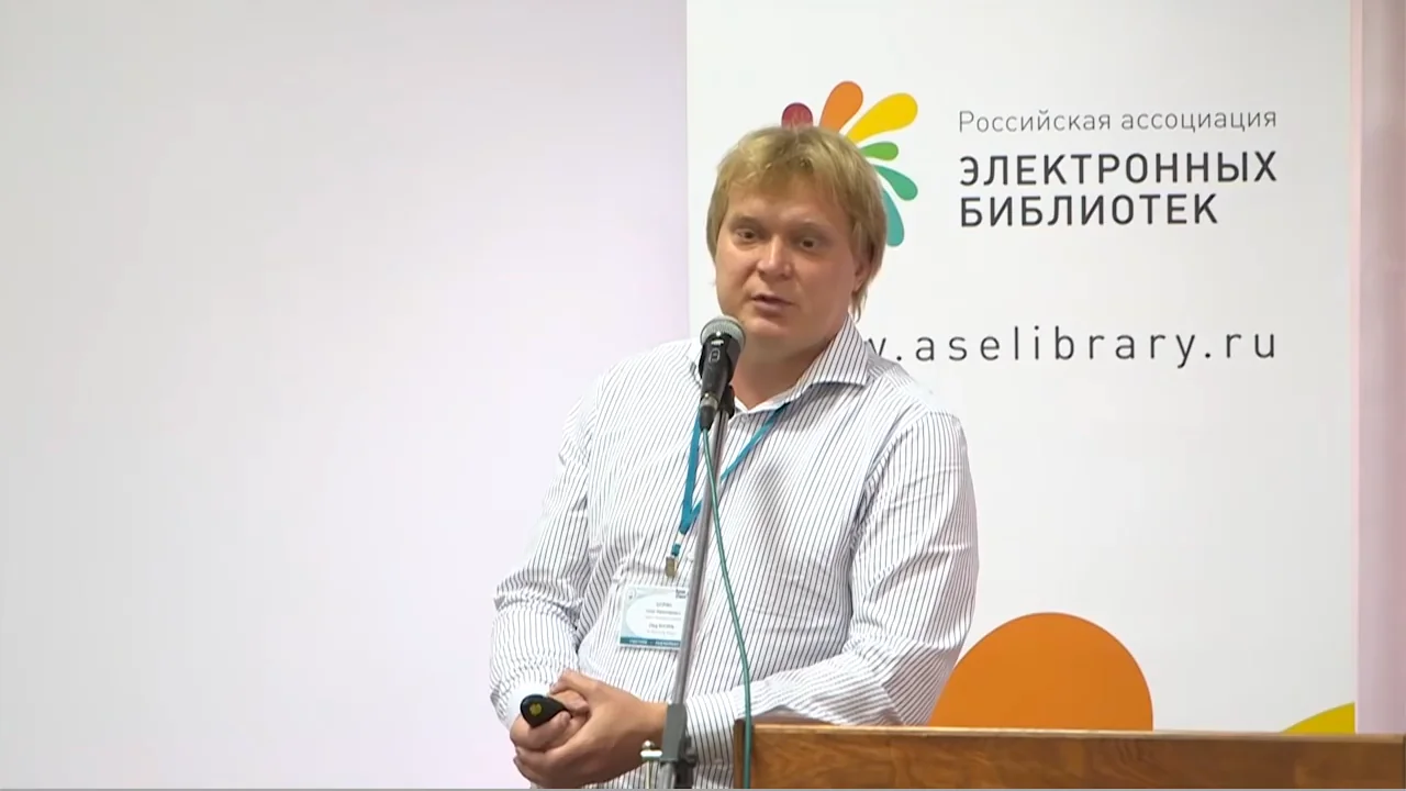 Олег Шорин выступает у микрофона на фоне баннера Российской ассоциации электронных библиотек
